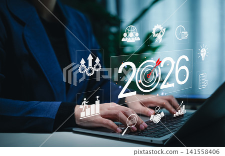 Business Goals and Growth Strategy for 2026 Concept. Businessperson working on a laptop with the year 2026, target icons, and business growth symbols, challenges strategic planning and future success. Business Goals and Growth Strategy for 2026 Concept. Businessperson working on a laptop with the year 2026, target icons, and business growth symbols, challenges strategic planning and future success. 141558406
