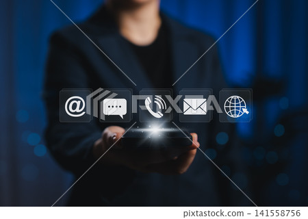Contact Us and Customer Support Service Concept. Businessperson holding smartphone with contact icons, including email, phone, chat, and web symbols, digital customer service, communication channel, Contact Us and Customer Support Service Concept. Businessperson holding smartphone with contact icons, including email, phone, chat, and web symbols, digital customer service, communication channel, 141558756