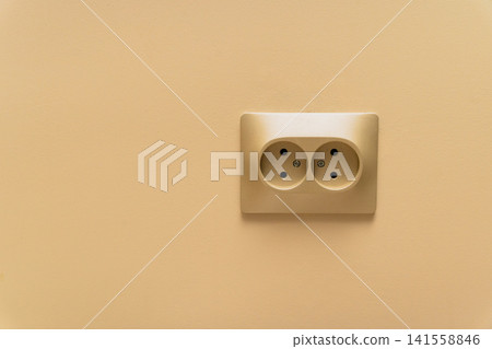 Electrical outlet on a plain wall in a simple indoor space during the day Electrical outlet on a plain wall in a simple indoor space during the day 141558846