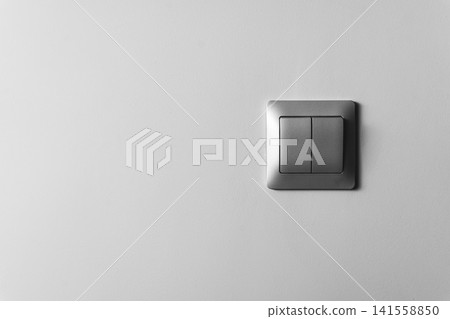 Two switch plates on a plain wall in a home or office setting Two switch plates on a plain wall in a home or office setting 141558850