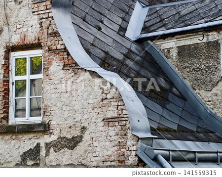 Weathered brick wall with bent metal roof flashing and window Weathered brick wall with bent metal roof flashing and window 141559315