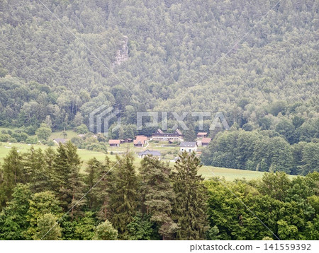 Rural mountain village nestled at forest edge 141559392