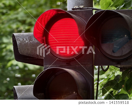 Close-up of illuminated red traffic light on urban pole Close-up of illuminated red traffic light on urban pole 141559518