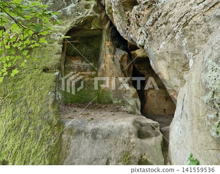 Mossy sandstone rock cave entrance in shaded woodland Mossy sandstone rock cave entrance in shaded woodland 141559536