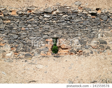 Weathered stone and mortar wall with narrow vertical opening Weathered stone and mortar wall with narrow vertical opening 141559578