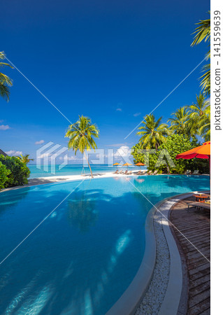 Romantic tropical infinity pool beside red umbrellas overlooking turquoise lagoon palm trees blue sky. Perfect summer vacation travel resort paradise. Luxury getaway relax leisure scenic 141559639