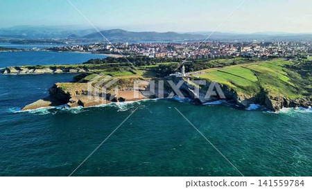 An aerial view shows the stunning coastal landscape with a lighthouse and vibrant city 141559784