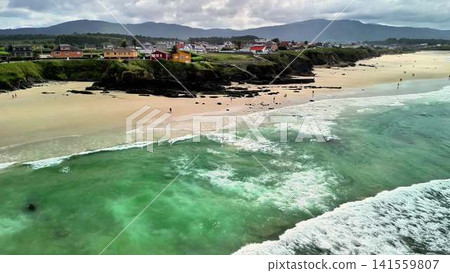 A breathtaking scenic coastal view featuring waves crashing against a sandy beach A breathtaking scenic coastal view featuring waves crashing against a sandy beach 141559807
