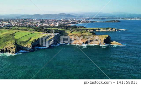 A scenic coastal view with a lighthouse and lush green hills, perfect for relaxation A scenic coastal view with a lighthouse and lush green hills, perfect for relaxation 141559813