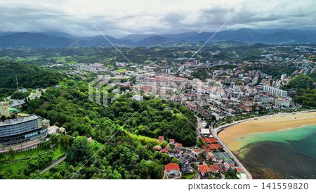 Enjoy a Scenic Aerial View of a Beautiful Coastal Town Surrounded by Lush Greenery and Nature Enjoy a Scenic Aerial View of a Beautiful Coastal Town Surrounded by Lush Greenery and Nature 141559820