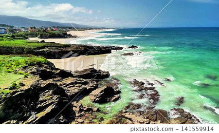 Stunning Coastal View of a Serene Beach and a Rocky Shoreline Surrounded by Natures Beauty 141559914