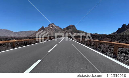 A scenic road winds through a volcanic landscape, offering breathtaking views that amaze travelers 141559938