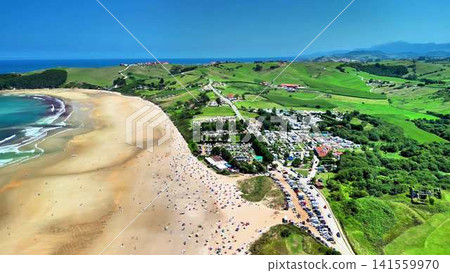 Stunning Aerial View of a Serene Beach Surrounded by Lush Green Hills and Clear Blue Skies Stunning Aerial View of a Serene Beach Surrounded by Lush Green Hills and Clear Blue Skies 141559970