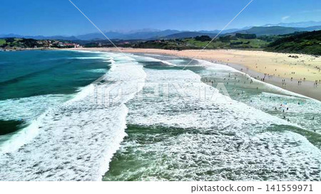Beautiful Coastal Beach with Gentle Waves, Happy Visitors, and a Serene Atmosphere Beautiful Coastal Beach with Gentle Waves, Happy Visitors, and a Serene Atmosphere 141559971