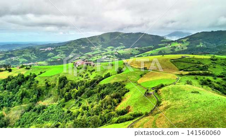 A Scenic Lush Green Hillscape Under a Beautiful, Cloudy Sky, Offering Tranquility A Scenic Lush Green Hillscape Under a Beautiful, Cloudy Sky, Offering Tranquility 141560060