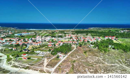 A breathtaking aerial view showcasing a picturesque coastal village beside the vast ocean A breathtaking aerial view showcasing a picturesque coastal village beside the vast ocean 141560142