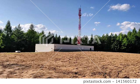 A Telecommunication Tower That is Beautifully Surrounded by a Lush Forested Area A Telecommunication Tower That is Beautifully Surrounded by a Lush Forested Area 141560172