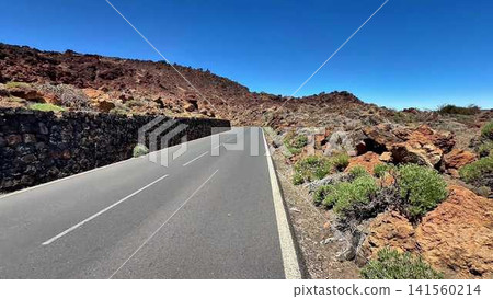 A Scenic Road Meandering Through a Volcanic Landscape Under a Clear Blue Sky on a Beautiful Day A Scenic Road Meandering Through a Volcanic Landscape Under a Clear Blue Sky on a Beautiful Day 141560214