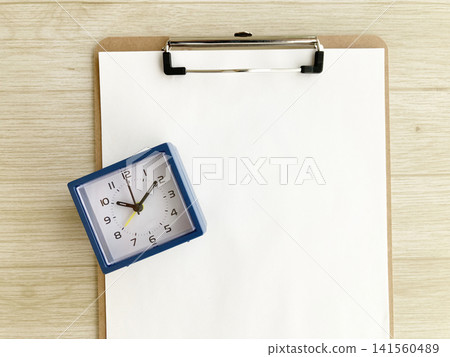 Wood grain background clipboard and desk clock - for time management, schedule and task management, deadlines, and work management. Wood grain background clipboard and desk clock - for time management, schedule and task management, deadlines, and work management. 141560489