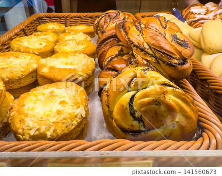 Braided buns and cheesecakes displayed in a wicker basket Braided buns and cheesecakes displayed in a wicker basket 141560673