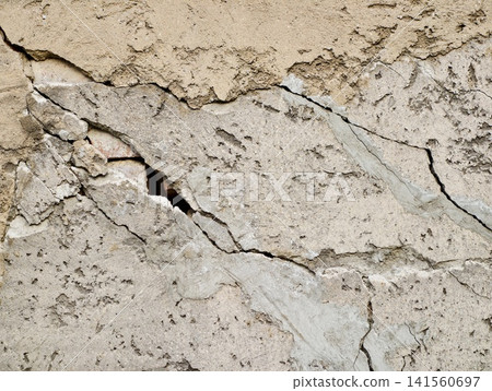 Damaged wall surface. Extensively deteriorated wall displaying surface cracks and weathered features Damaged wall surface. Extensively deteriorated wall displaying surface cracks and weathered features 141560697