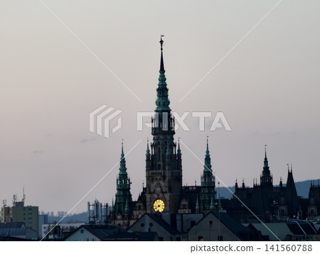 Silhouette of historic gothic church with detailed spires illuminated at sunset in urban setting Silhouette of historic gothic church with detailed spires illuminated at sunset in urban setting 141560788