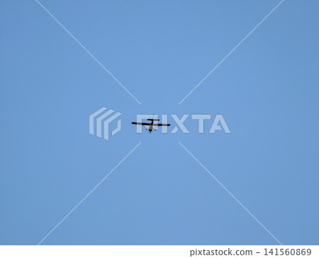 Pilot flying jet amidst calm weather. Training aircraft navigating sky with focused precision 141560869