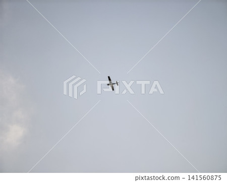 Skyline framed by gentle sunlight. Bright afternoon with single plane drifting softly above tranquil waters Skyline framed by gentle sunlight. Bright afternoon with single plane drifting softly above tranquil waters 141560875