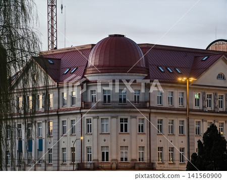 Historic European edifice features decorative neoclassical elements and warm lighting at dusk Historic European edifice features decorative neoclassical elements and warm lighting at dusk 141560900
