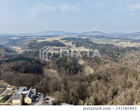 Forest hills meet city outskirts. Aerial perspective captures suburbs beside wooded mountain slope Forest hills meet city outskirts. Aerial perspective captures suburbs beside wooded mountain slope 141560943