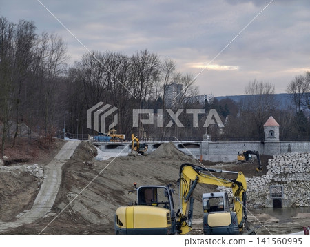 Multiple tracked excavators cooperate diligently to reinforce riverbanks and prevent flooding Multiple tracked excavators cooperate diligently to reinforce riverbanks and prevent flooding 141560995