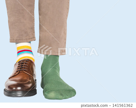 Man in beige pants, striped socks and one brown shoe Man in beige pants, striped socks and one brown shoe 141561362