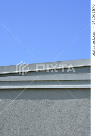 Minimalist concrete building rooftop edge against a blue sky Minimalist concrete building rooftop edge against a blue sky 141561670