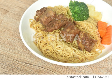 Chinese yellow egg nodles topping braised slice honey pork bone stew dressing black herb sauce with boiled vegetable on plate Chinese yellow egg nodles topping braised slice honey pork bone stew dressing black herb sauce with boiled vegetable on plate 141562952