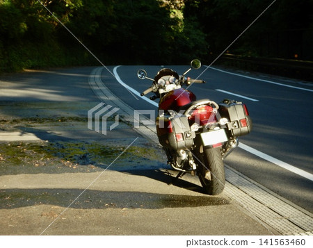 Motorcycle parked on the side of the road 141563460