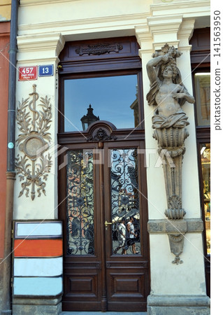 Carved wooden doorway with sculpted caryatid and iron grill in Prague historic street for travel banner and architectural background Carved wooden doorway with sculpted caryatid and iron grill in Prague historic street for travel banner and architectural background 141563950