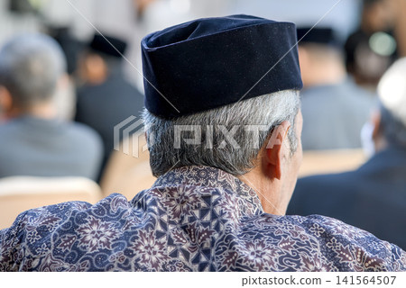 rear view of senior man in suit and tie sitting in the conference hall or seminar meeting, business and education concept rear view of senior man in suit and tie sitting in the conference hall or seminar meeting, business and education concept 141564507