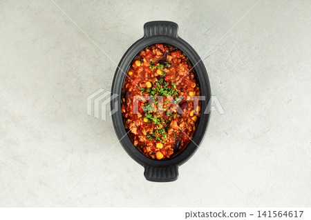 Traditional Mexican chili stew with vegetables in black bowl Traditional Mexican chili stew with vegetables in black bowl 141564617