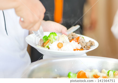Close-up view of a festive dining moment showing a hand reaching for delicious food served on the table. 141564751
