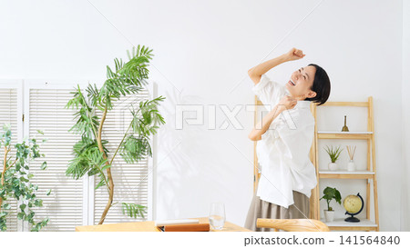 一位中年婦女在房間裡跳舞。她放鬆、微笑、快樂、喜悅、有趣、精力充沛、跳舞、滿足、自由、無拘無束,是一位家庭主婦。 一位中年婦女在房間裡跳舞。她放鬆、微笑、快樂、喜悅、有趣、精力充沛、跳舞、滿足、自由、無拘無束,是一位家庭主婦。 141564840