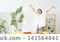 A middle-aged woman dancing in her room. Relaxed, smiling, happy, joyful, fun, energetic, dancing, satisfied, liberated, free, housewife. 141564841