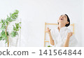 A middle-aged woman makes a triumphant gesture in her room. Happy, delighted, having fun, energetic, positive, relaxed, smiling, satisfied. 141564844