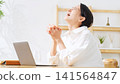 A middle-aged woman looks disappointed at her laptop. Feeling down, a failure, disappointed, frustrated, rejected, shocked, streaming, crying. 141564847