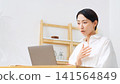 A middle-aged woman speaking into a laptop. (Web conference, video call, lesson, webinar, broadcast, seminar) 141564849