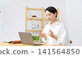 A middle-aged woman speaking into a laptop. (Web conference, video call, lesson, webinar, broadcast, seminar) 141564850