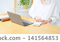 A woman using a laptop and calculator. (Keywords: household finances, bookkeeping, accounting, calculations, finance, estimation, freelance, qualifications) 141564853