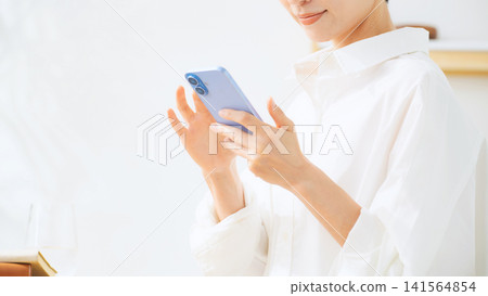 中年女性使用智慧型手機。應用程式、社群媒體、影片、智慧型手機、行動、電子郵件、休閒、手機。 中年女性使用智慧型手機。應用程式、社群媒體、影片、智慧型手機、行動、電子郵件、休閒、手機。 141564854