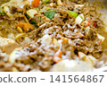 Close-up view of a festive dining moment showing a hand reaching for delicious food served on the table 141564867