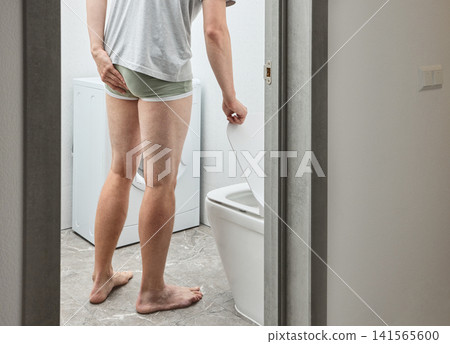 Man in bathroom suffering from chronic constipation and painful bowel movement. Gastroenterology exam and digestive tract obstruction relief. Man in bathroom suffering from chronic constipation and painful bowel movement. Gastroenterology exam and digestive tract obstruction relief. 141565600