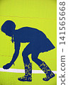 Blue Silhouette Street Art of Girl Bending Over in Patterned Boots on Lime Green Wall. 141565668